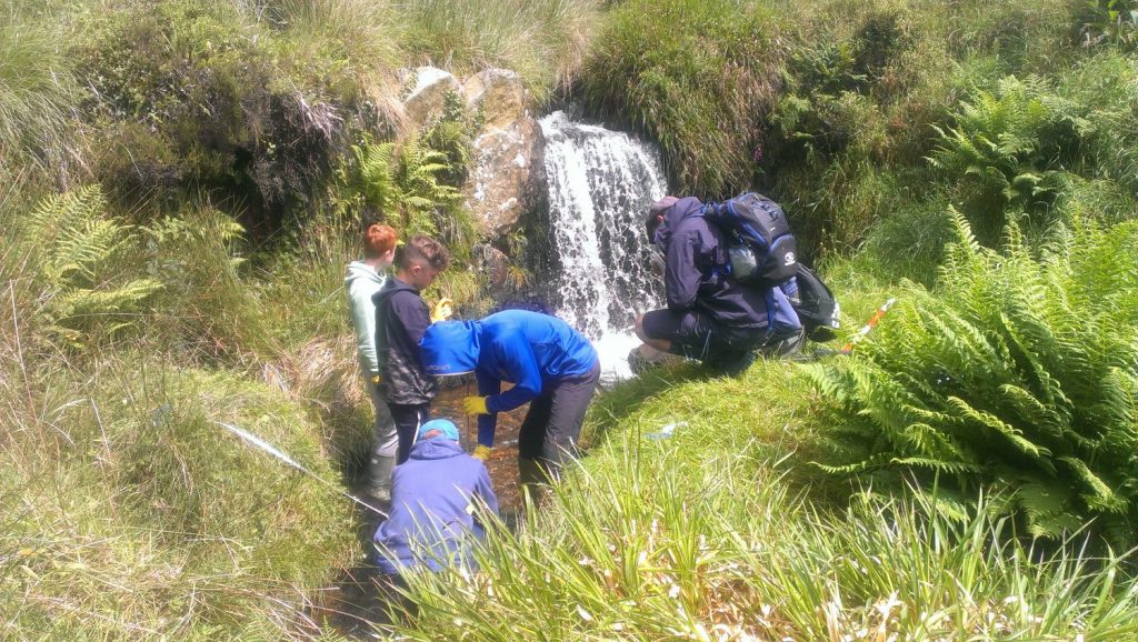 GCSE pupils measuring river channel and water flow in the Syfynwy River, Pembrokeshire Coast National Park, Wales, UK