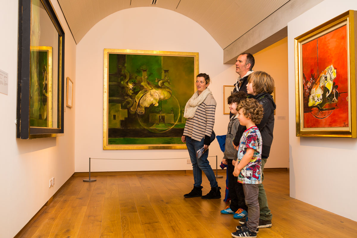 A family is viewing a Graham Sutherland painting at Oriel y Parc