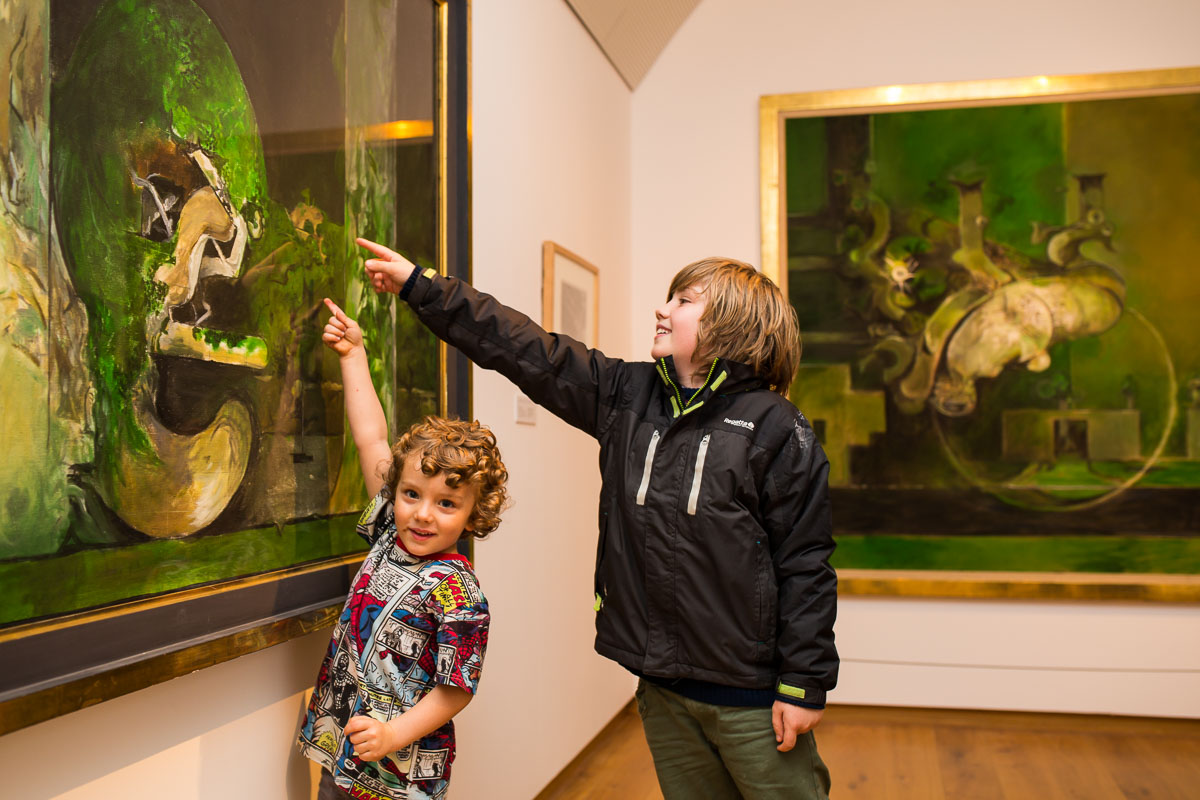 Two boys are pointing to a Graham Sutherland painting in the gallery at Oriel y Parc
