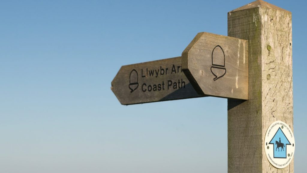 Wooden coast path direction sign, Pembrokeshire Coast Path, Pembrokeshire Coast National Park, Wales, UK