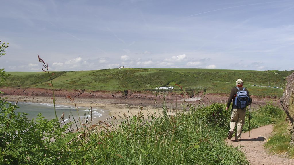 Walker on the Pembrokeshire Coast Path approaching Manorbier