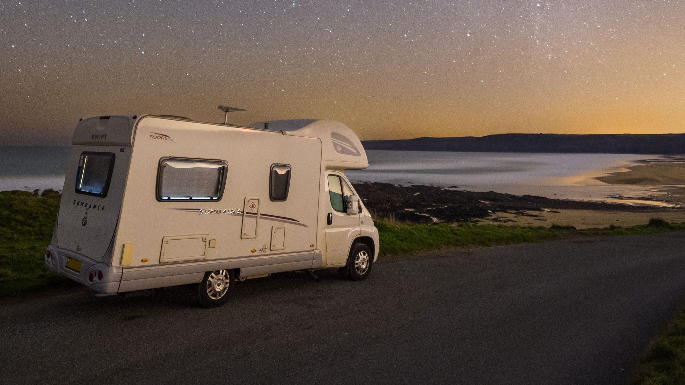 Campervan parked near coastline at dusk