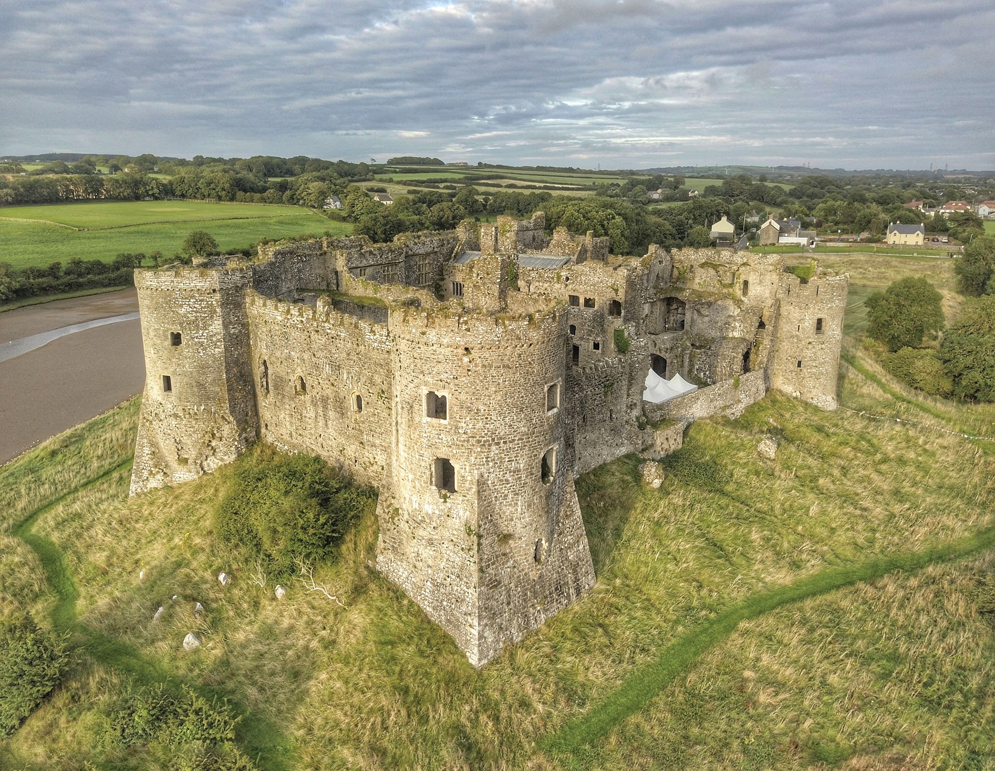 Aerial photograph of a ruined stone castle located next to a river