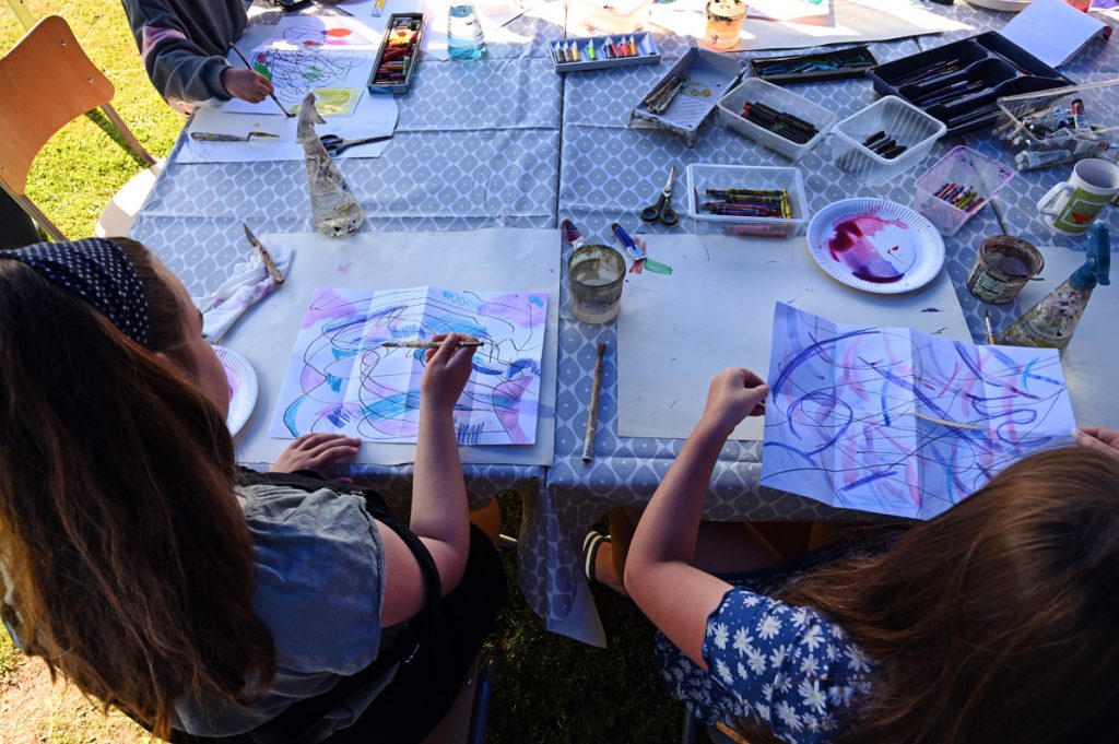 Group of children sitting around a table painting as part of workshop