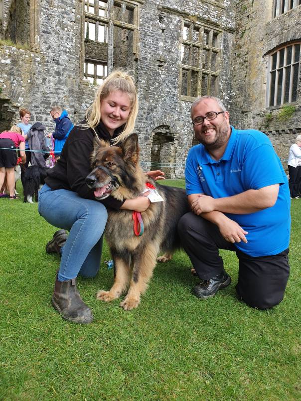 A prize-winning dog at Carew Castle with owner and Castle staff.