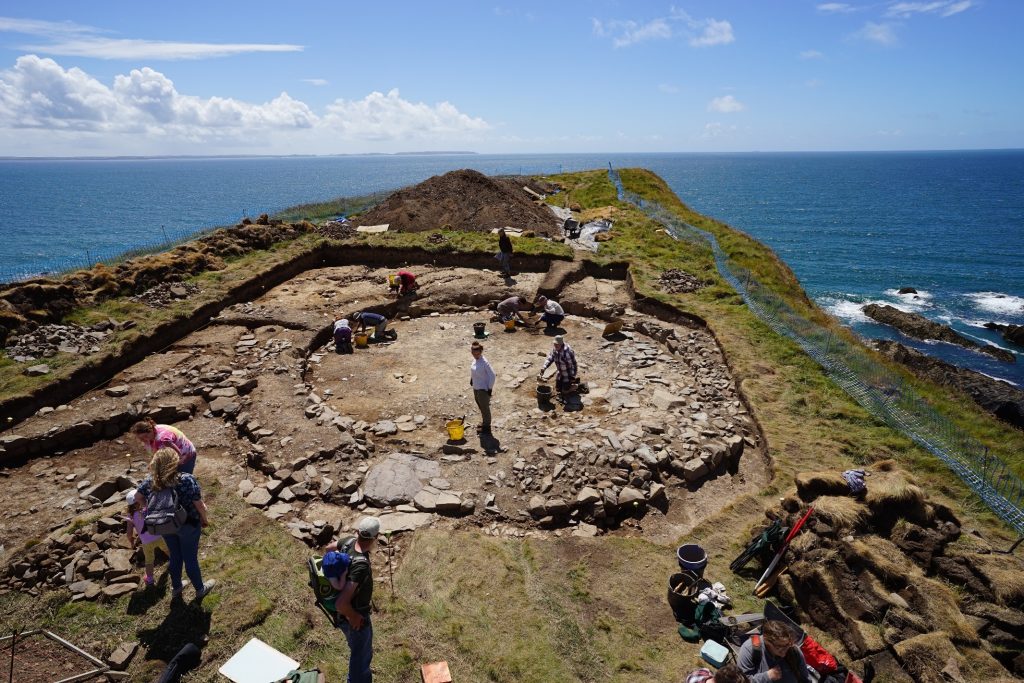 Aerial photograph of an archaological dig on a cliff top promontory fort. Location is Porth y Rhaw near Solva, Pembrokeshire, Wales, UK