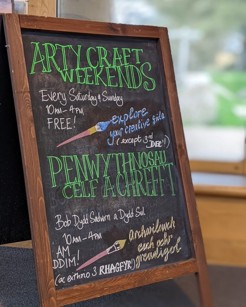 Sandwich 'A' board advertising Arty craft weekends at Oriel y Parc Gallery and Visitor Centre in St Davids