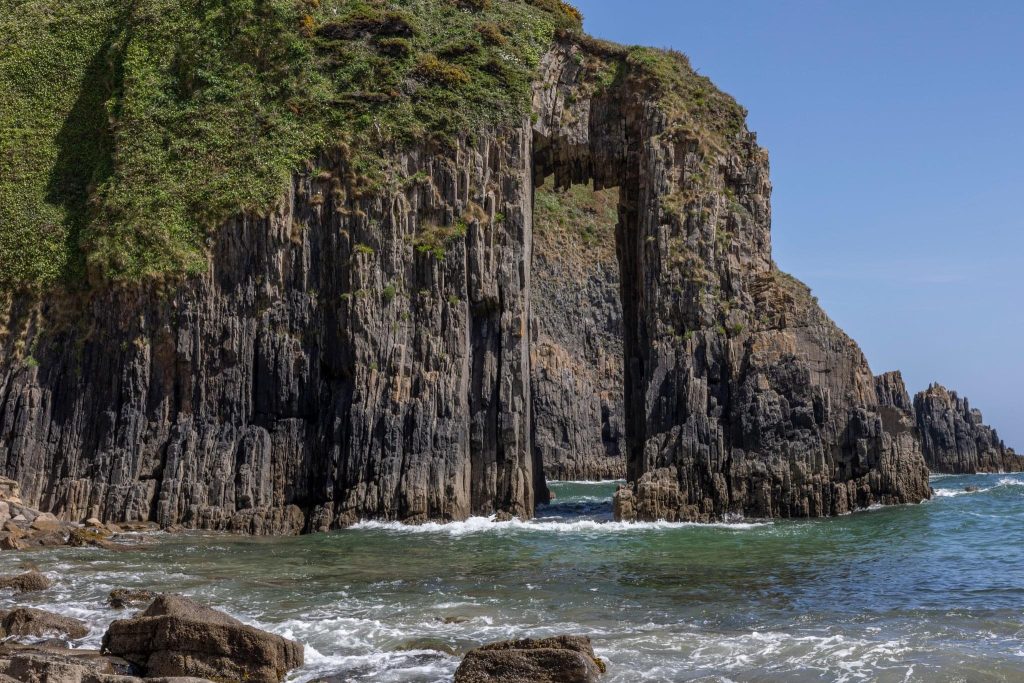 Limestone arch with almost perfect rectangular gap through the middle of it. Location is Church Doors, Pembrokeshire