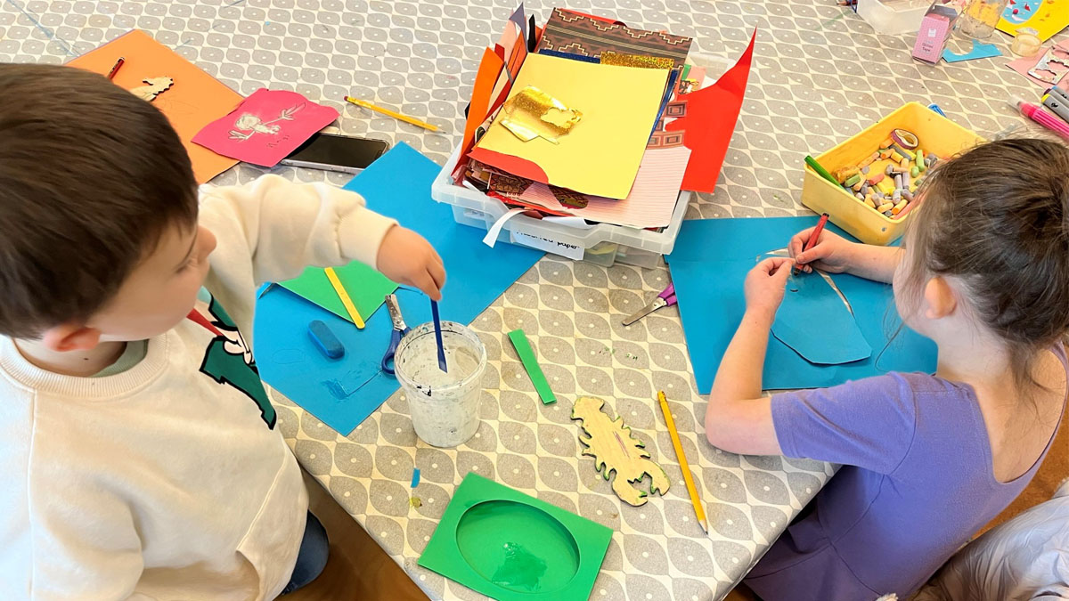 Two children enjoying an arts and crafts activities with mixed crafts materials