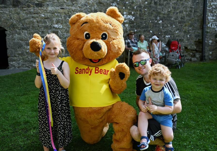 Sandy Bear at Carew Castle with a young family