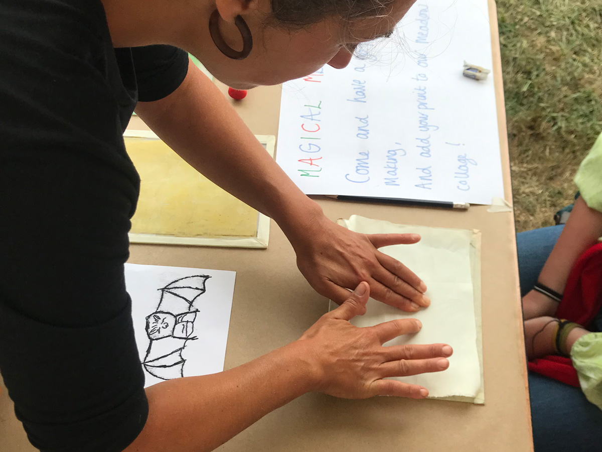 Woman leaning over table making a print as part of an arts and crafts activity 