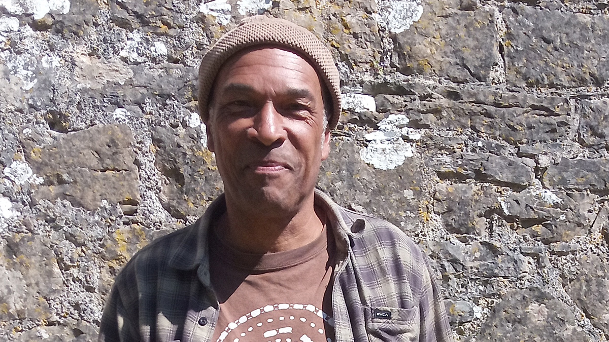 Man standing in front of stone castle wall. Man pictured is Phil Okwedy.