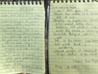 Poem written in a notebook. it reads: Sea mist rolls in and stays all day Leaving Newgale, the ocean voice recedes muffled by heavy air And i am left with the uphill seound of my labouring breath Then settles into gentle rhythm It's just me and the path, retracing steps homeward The view obscured and fire ravaged hillside, charred remains. Small bursts of colour, yellow gorse peppered with heather pinks Signs of life, half blown dandelion clock, seeds sown to time, whispering hope  Round the corner is a field full of sun Reflecting on September warmth, miles covered, salty skin, birdsong, red admiral wings brush my cheek, a blessing  Contented fatigue, nature's gift. This is the reason I am here, lost words found in wondering. Uttered prayer of movement brings still to the mind. -Emma, Cardiff