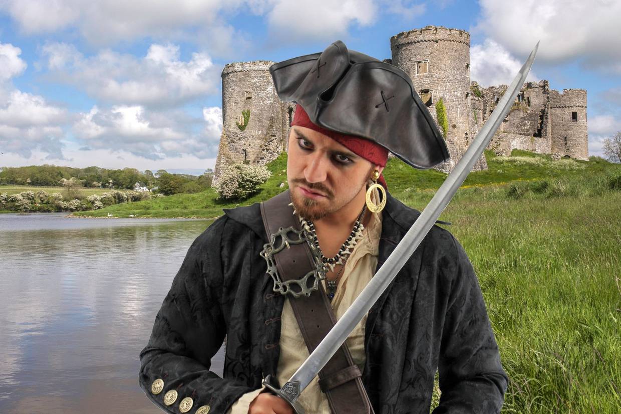 A mean-looking pirate with a cutlass, with Carew Castle in the background