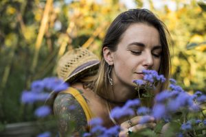 Woman smelling Vervain flowers in her garden