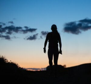 A silhouette of Sanna Duthie against a dusk sky
