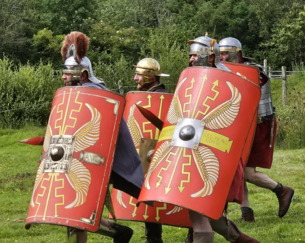 Roman solders with red shields advancing on Castell Henllys