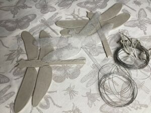 image of unfired clay dragonflies with wire