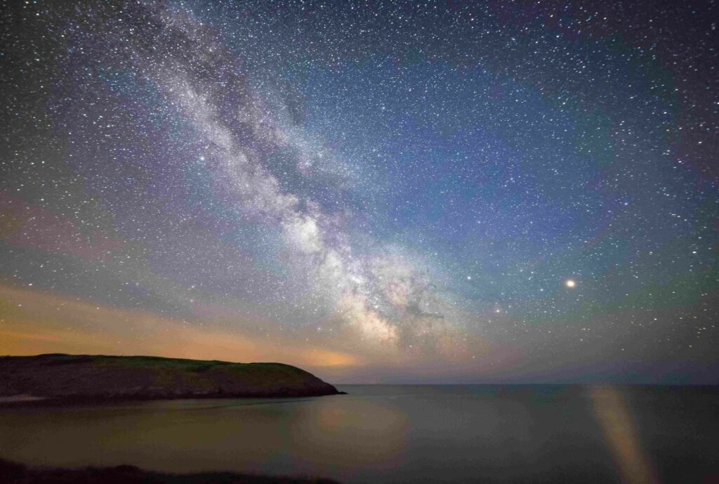A starry sky over Manorbier beach, with the Milky Way visible