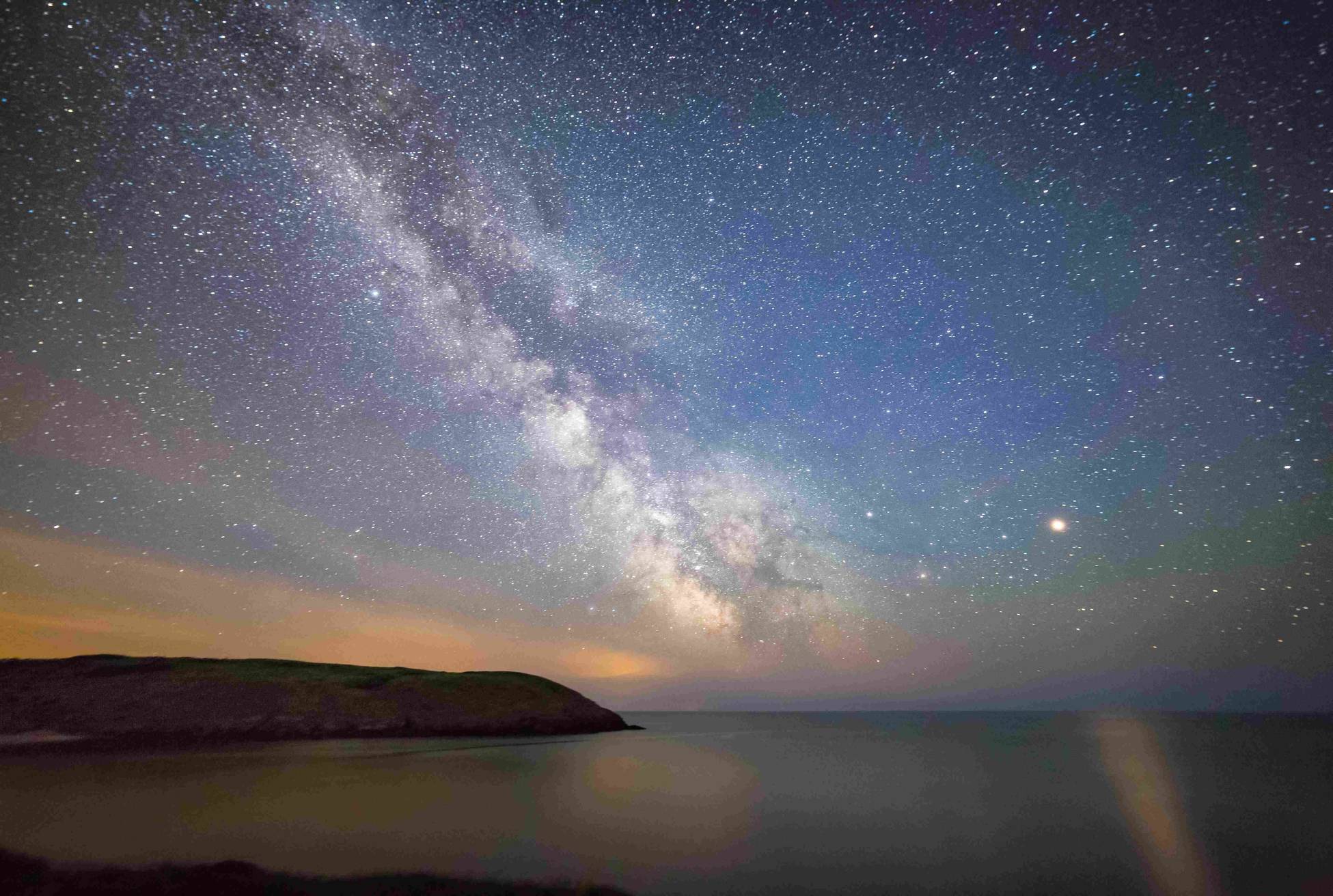 A starry sky over Manorbier beach, with the Milky Way visible
