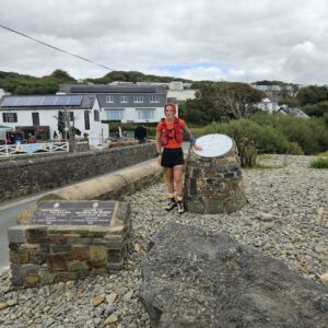 Sanna Duthie standing by a Coast Path marker